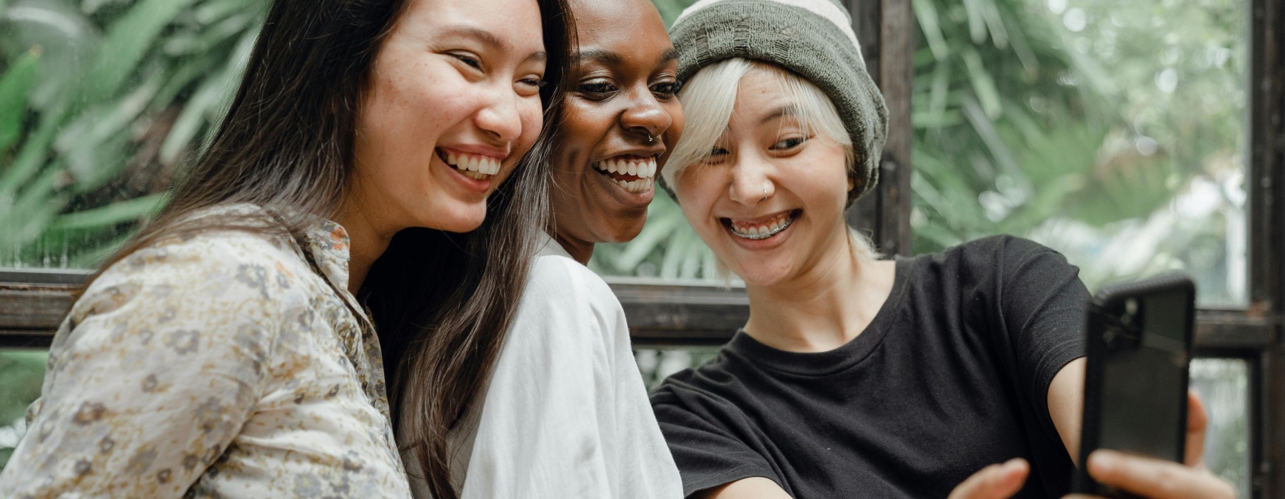 three women looking onto a device